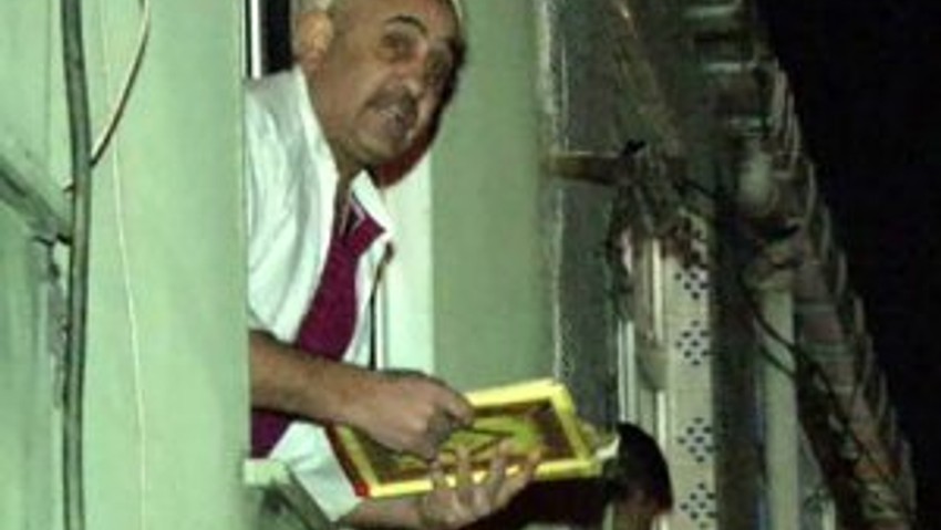 Eline Kur'an-ı Kerim'i alıp cama çıktı
