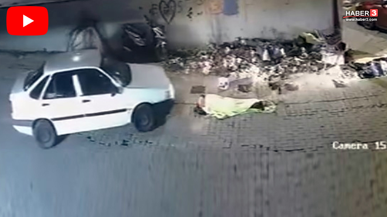 İzmir'de kaldırımda uyuyan bir kişinin otomobilin üzerinden geçtiği anı gösteren güvenlik kamerası görüntüsü.