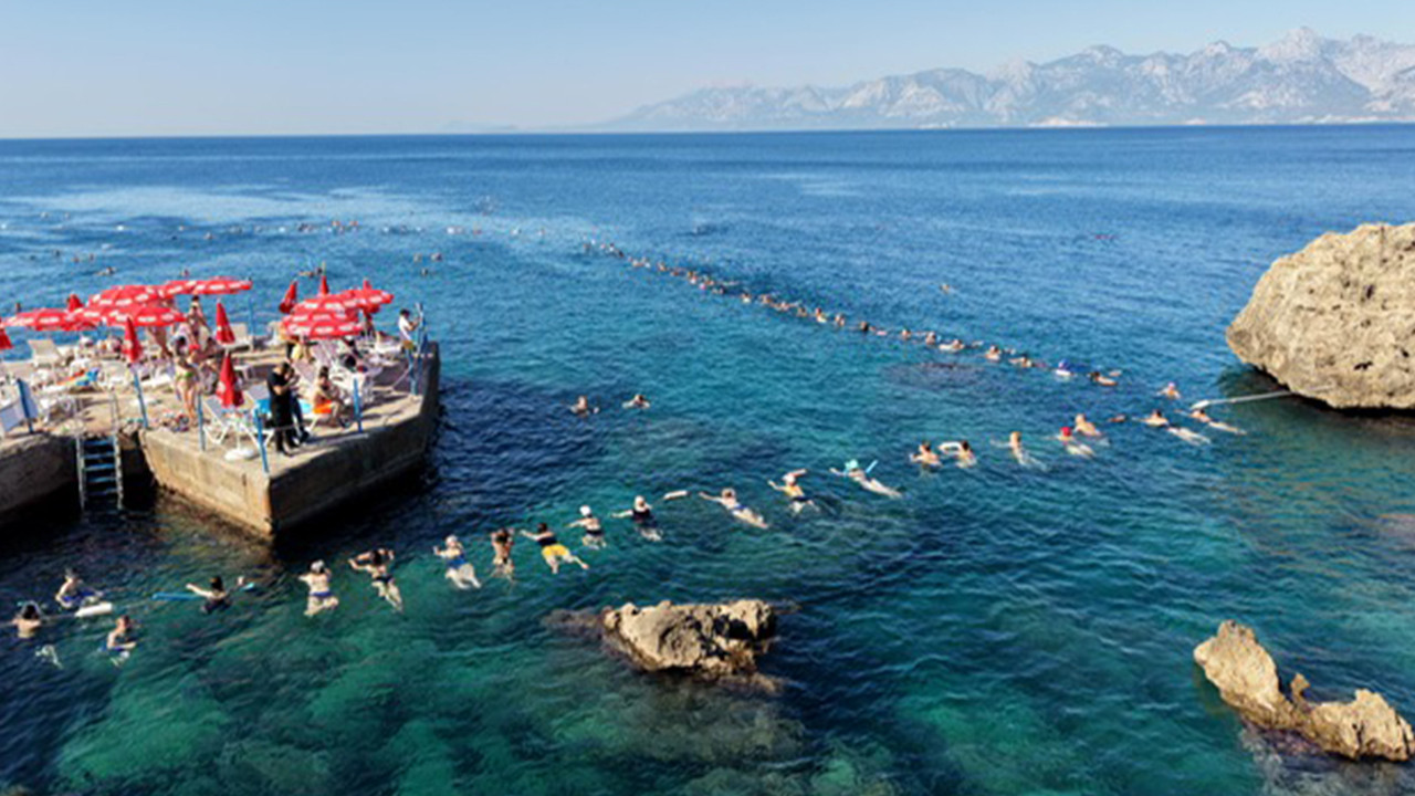 Antalya'da bir plajda su cimnastiği dersi alan insanlar