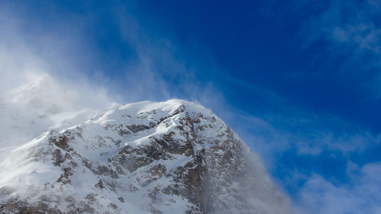 Elbruz Dağı'nın karla kaplı zirvesi ve dağcıların tırmanışını gösteren temsili bir görsel.
